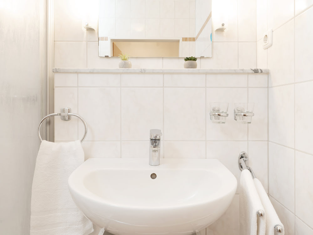 Badezimmer mit Waschbecken und Spiegel Badezimmer mit Waschbecken und Spiegel