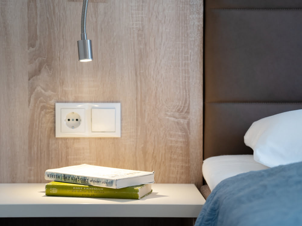Nachttisch mit Leselampe am Doppelbett Nachttisch mit Leselampe am Doppelbett